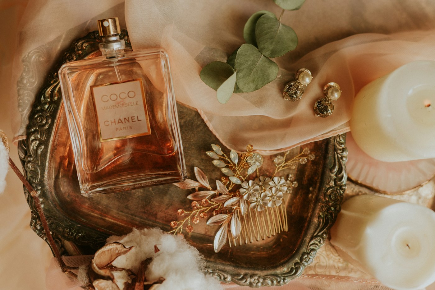 Perfume on a vintage tray with candles and dried flowers